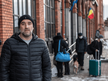 Eine Person steht vor einem Gebäude mit rumänischer Flagge_942417_Rumänien