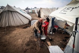 Ein palästinensischer Mann bereitet vor seinem Zelt in einem Vertriebenenlager in Rafah im südlichen Gazastreifen, wo die meisten Zivilisten Zuflucht gefunden haben, Essen für seine Familie zu.