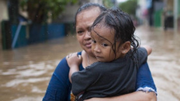 Mutter mit Kind in Überschwemmung